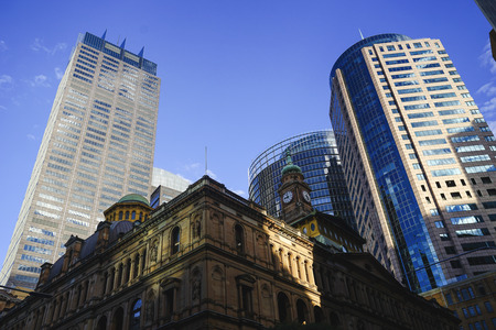 low angle of combination of heritage vintage building and high modern buildings in city with blue skyのeditorial素材