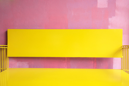 Vintage bright yellow Bench Against grunge pink painted Wall, bright summer colourの写真素材