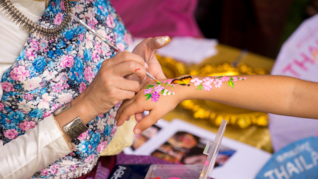 A Beautiful Thai woman in Thai transnational dress was painting kid's hand with paintbrush in Thailand Grand Festival in Sydney, 24-25/03/18. Australiaのeditorial素材