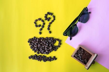 top view flat layer coffee beans in cup and smell icon shape and sunglasses on two tone multi coloured backgroundの写真素材