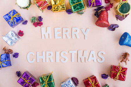 merry christmas   wooden word with colourful christmas gift boxes in backgroundの写真素材