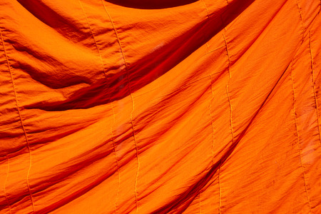 texture of orange robe of a buddhist monk or novice for backgroundの写真素材