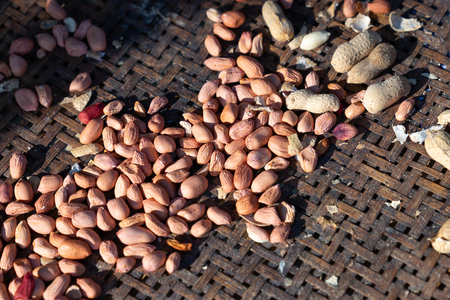 raw peeled peanuts on old bamboo basketの写真素材