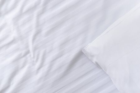 top view corner of white pillow on white clean bed close up, copy spaceの写真素材