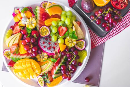 close up large tray of sliced assorted fresh tropical fruits platterの写真素材