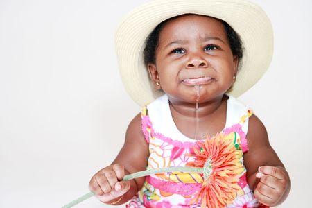 Angry Baby Girl Drooling With Flower in Right Handの写真素材