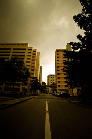 A stretch of road leading to some apartments in the eveningの写真素材