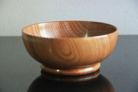 Wood cup on a glass top with a plain backgroundの写真素材