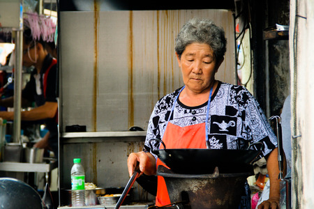 Elderly lady cooking at her food stall in Penangのeditorial素材