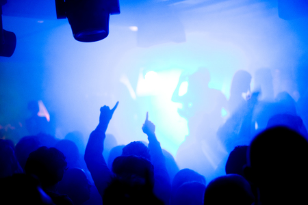 Party people having fun at the electronic party. Blue backgroundの写真素材