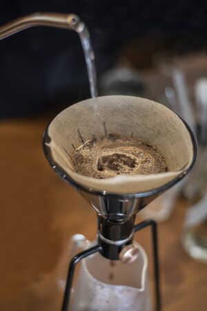 Hot steam dripped coffee with paper coneの写真素材