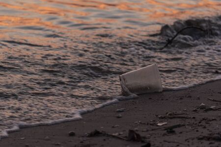 Plastic cup garbage on the beach is an environment pullution issuse for seaの写真素材
