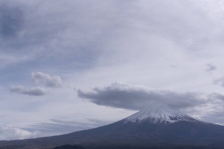Snowcapped and cloud hat phenomena against the most beautiful volcanoの写真素材