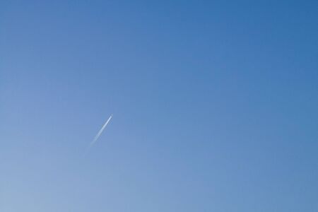 Cloud jet of fly high airplane on empty blue sky backgroundの写真素材