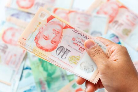Hand holding Singapore Dollar banknote,Background