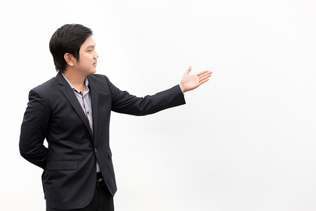 Welcome! young Asian business man in formalwear gesturingwhile standing isolated on white background.の写真素材