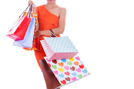 Women wearing orange dress holding shopping bags.の写真素材