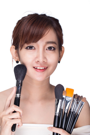 Woman holding a brush on a white background.の写真素材
