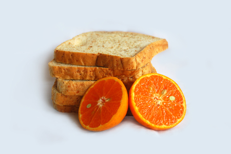 Whole wheat bread with slice orange on whiteの写真素材