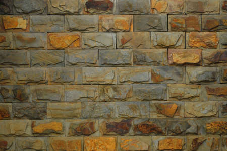 antique stone wall is gray color flecked with yellow and brown, it rough surface and look strong