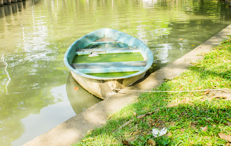 Old rowboat in canal, plastic rowboatの写真素材