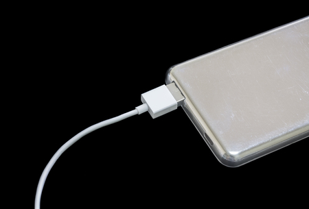 Portable power bank for charging mobile devices, isolated on black backgroundの写真素材
