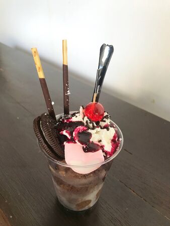 Homemade chocolate ice cream with topping in a cupの写真素材