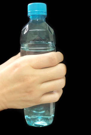Hand holding a clear plastic bottle of pure drinking water refreshing on black backgroundの写真素材