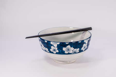 chinese ceramic bowel and black chopsticks on white scene,shallow focusの写真素材