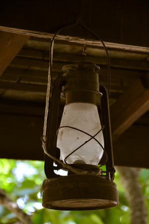 Old rusty kerosene oil hang on woodの写真素材