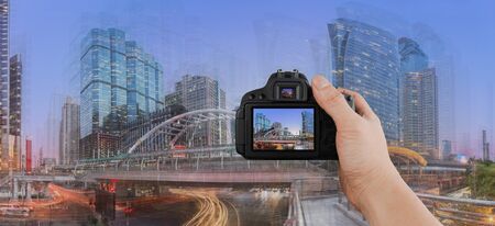 Photographer shooting modern building at twilight. Traffic in the busy business districtの写真素材