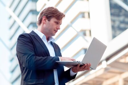 Young business man uses a laptop to find information about investments and businesses
