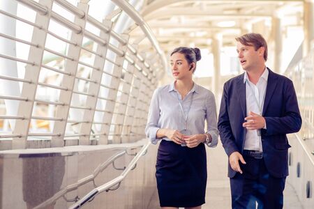 Business men talk to business women While walking and resting on the Skywalk, Teamwork, partnership concepの写真素材
