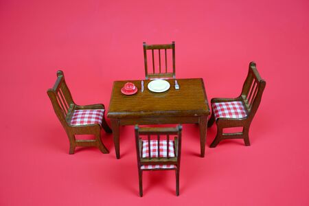 Breakfast set is placed on a separate wooden table on the red background.