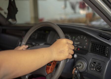 close up of male hands pushing button on the steering wheel in the car.の写真素材