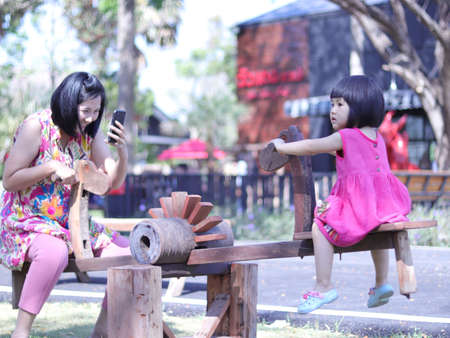 Mother took a picture of his daughter playing rocking horse.のeditorial素材