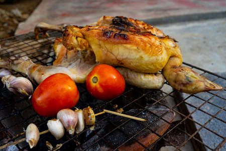 Grilled chicken with spices on a steel grill charcoalの写真素材