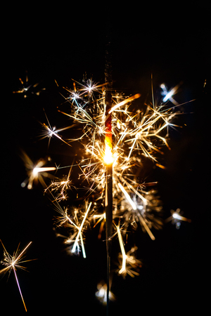 Burning sparkler isolated on black background blurの写真素材