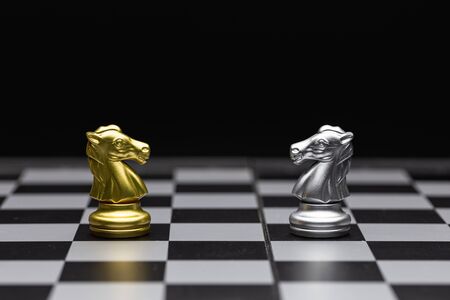 Chess of silver and gold horses face each other in a chess game detail object artの写真素材
