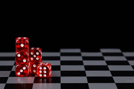 Red dice on a chessboard in a black background detail artの写真素材