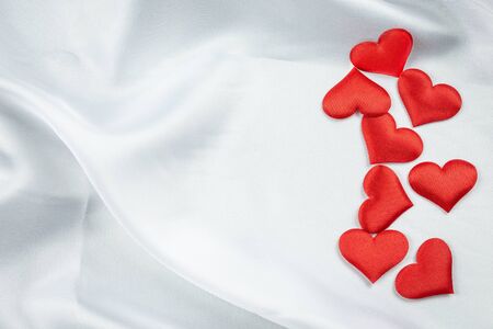 Many red hearts on a wrinkled white background detail objectの写真素材