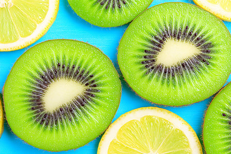 Discover a lively arrangement of sliced kiwi and lemon on a bright pastel background, showcasing vibrant colors and fresh textures. Perfect for summer vibes!の素材