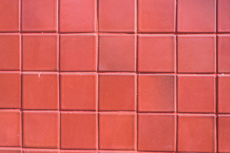 A wall of red tile aging by time and faded by weather. A fine work and background for house designの写真素材