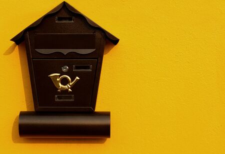 Brown mailbox on the yellow wall.の写真素材