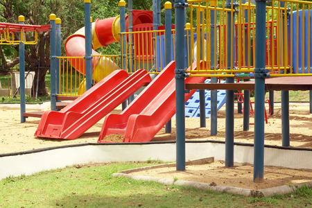 Colorful playground in public park, slide and swing on yard activities for children.