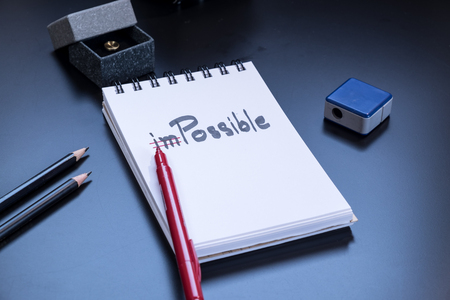 Change the word impossible to possible on a notepad.Conceptual of positive attitude.の写真素材
