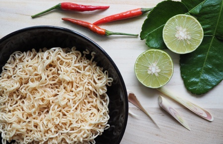 Instant noodles in black bowl on wood backgroundの素材