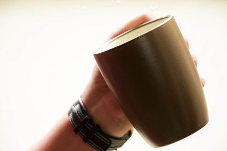 cup with coffee in hand on white の写真素材