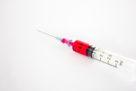 Syringe with red liquid on white background (Focus on red liquid)の写真素材