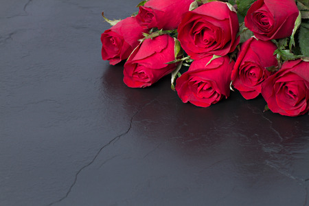 Red roses on black stone background. Valentine's day background.の写真素材